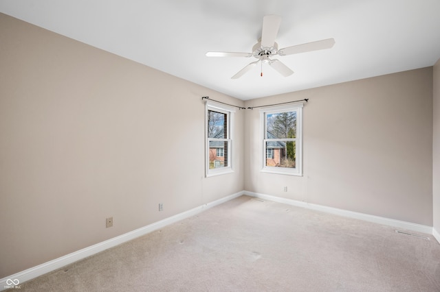 unfurnished room featuring light carpet, ceiling fan, and baseboards