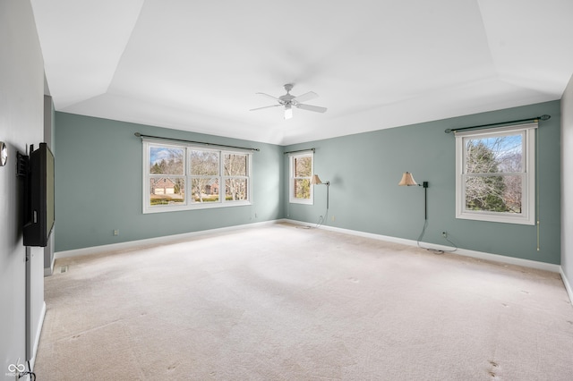 carpeted spare room featuring a ceiling fan and baseboards