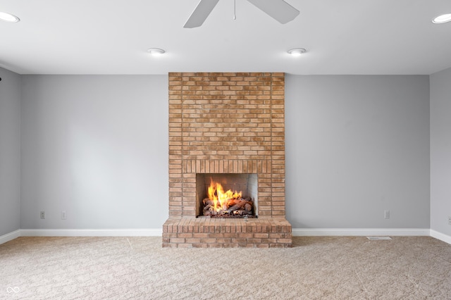 unfurnished living room featuring recessed lighting, a ceiling fan, baseboards, a brick fireplace, and carpet