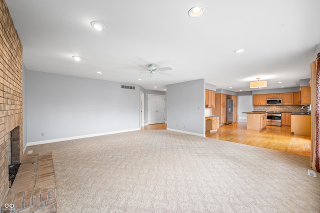 unfurnished living room featuring recessed lighting, visible vents, a brick fireplace, light carpet, and baseboards