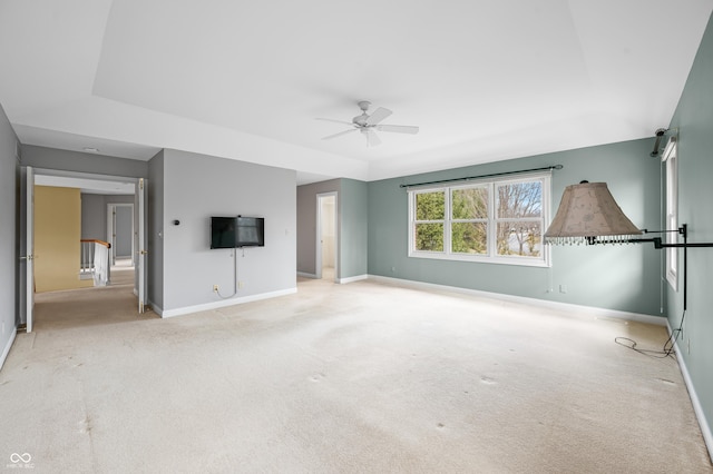 unfurnished living room featuring carpet flooring, ceiling fan, and baseboards