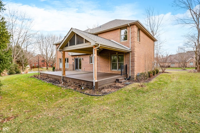 back of house featuring a yard, roof with shingles, a patio, and brick siding