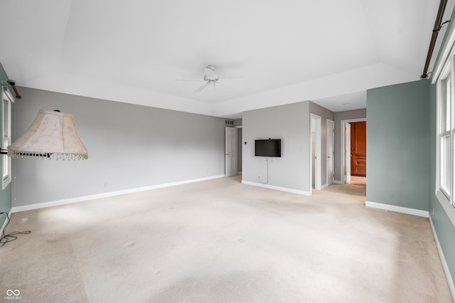 interior space featuring light carpet, ceiling fan, baseboards, and vaulted ceiling