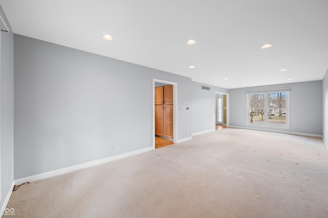 unfurnished living room featuring recessed lighting, visible vents, baseboards, and light colored carpet