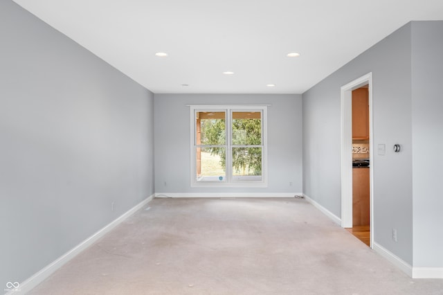 unfurnished room featuring light carpet, baseboards, and recessed lighting