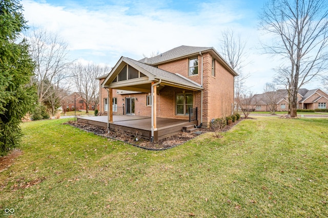 rear view of house featuring brick siding, a lawn, a patio area, and a shingled roof