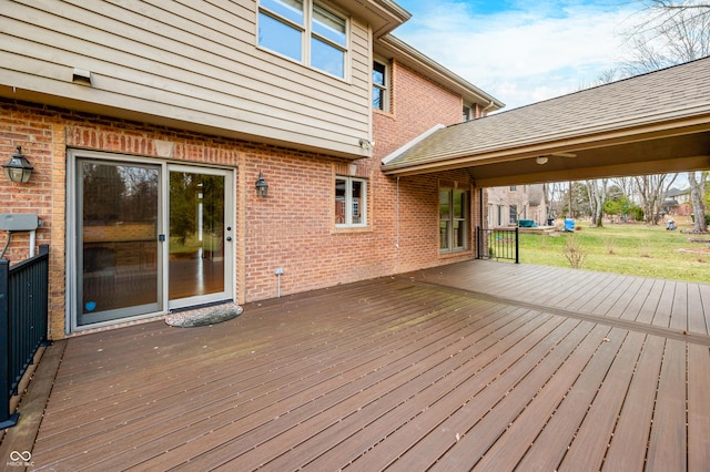 wooden deck featuring a lawn