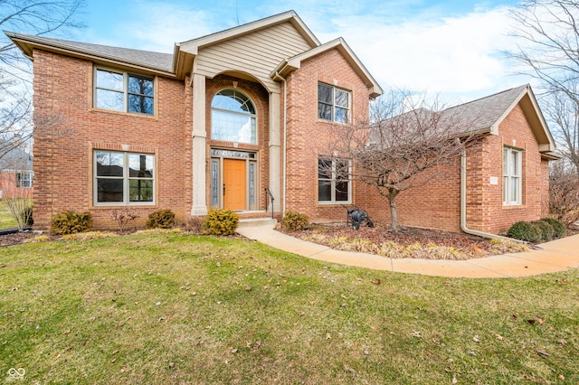 traditional home with a front yard and brick siding