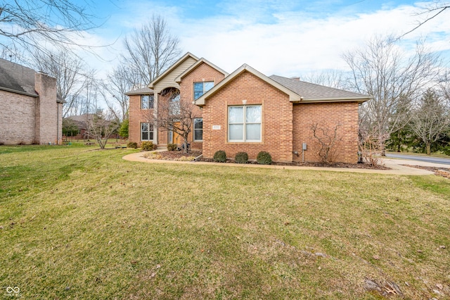 traditional-style home with a shingled roof, a front lawn, and brick siding