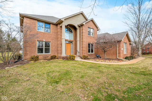 traditional-style home featuring a front yard and brick siding