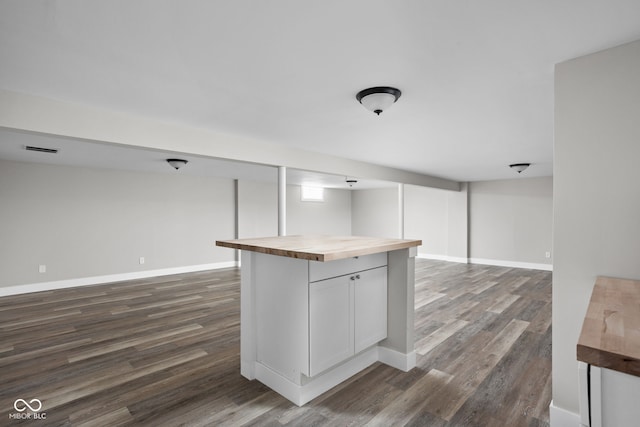 kitchen with visible vents, dark wood-type flooring, open floor plan, butcher block countertops, and baseboards