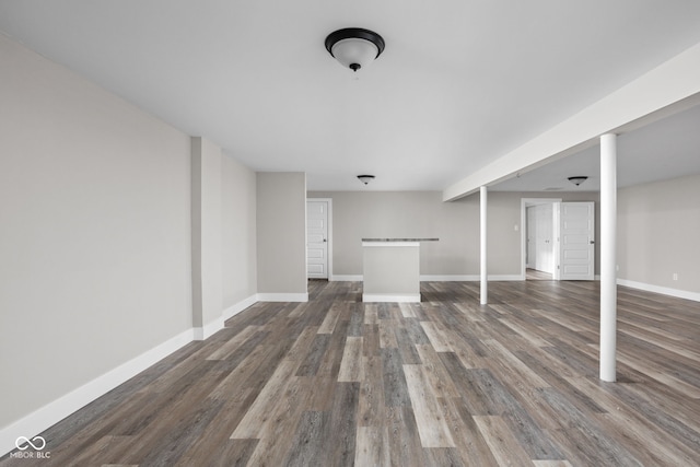 unfurnished living room featuring wood finished floors and baseboards