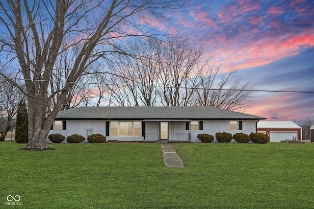 ranch-style house with an attached garage, roof with shingles, a lawn, and brick siding