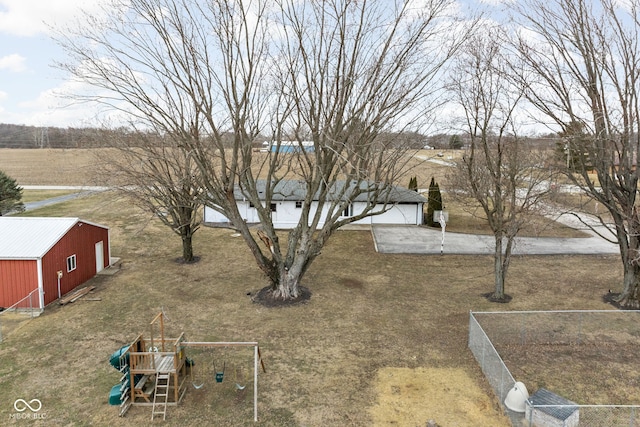 view of yard with fence, a playground, and an outdoor structure