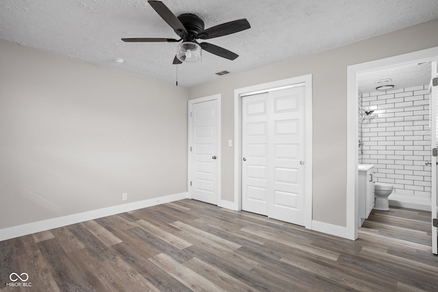 unfurnished bedroom featuring a textured ceiling, wood finished floors, and visible vents