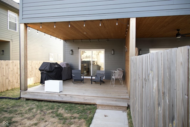 wooden terrace with fence and a grill