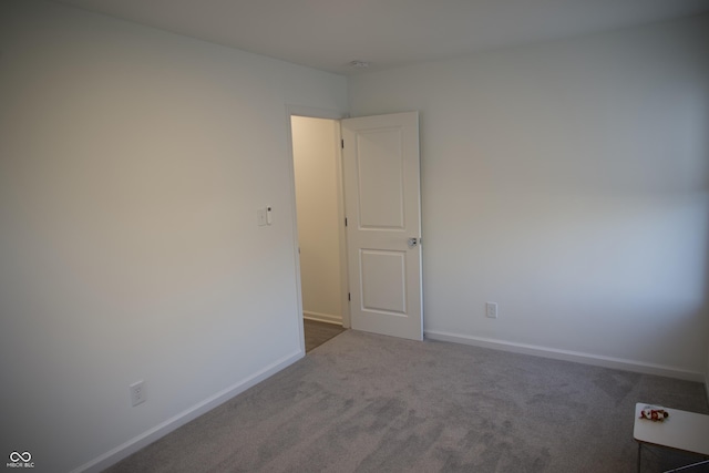 carpeted empty room with baseboards