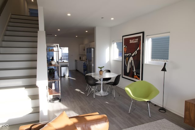 dining area with recessed lighting, baseboards, wood finished floors, and stairs