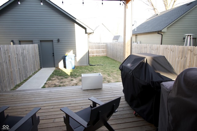 wooden terrace featuring area for grilling and a fenced backyard