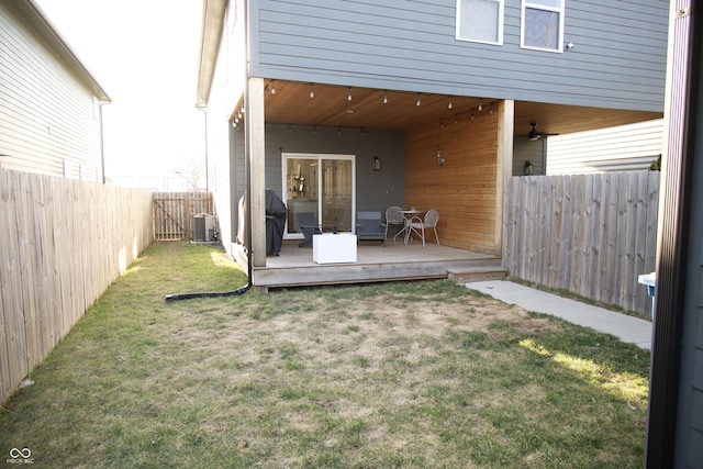 view of yard with a wooden deck, central air condition unit, and a fenced backyard