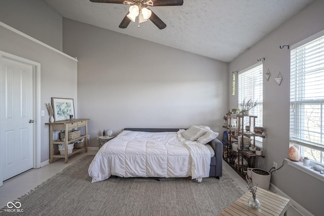 bedroom featuring baseboards, a textured ceiling, a ceiling fan, and vaulted ceiling