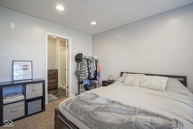 bedroom with ensuite bath, recessed lighting, carpet floors, and a textured ceiling