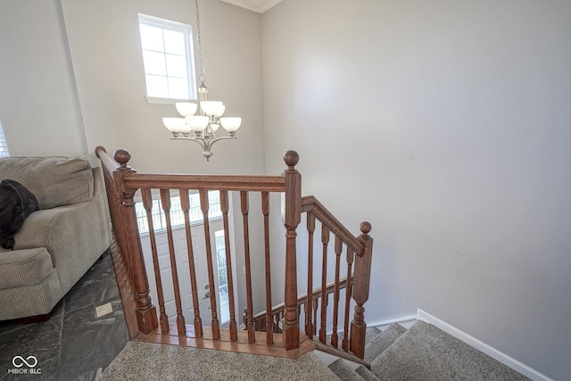 stairway featuring a chandelier and baseboards