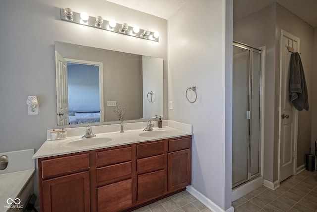 bathroom with a shower stall, double vanity, and a sink