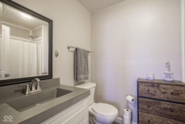 bathroom with a shower with shower curtain, toilet, vanity, and a textured ceiling