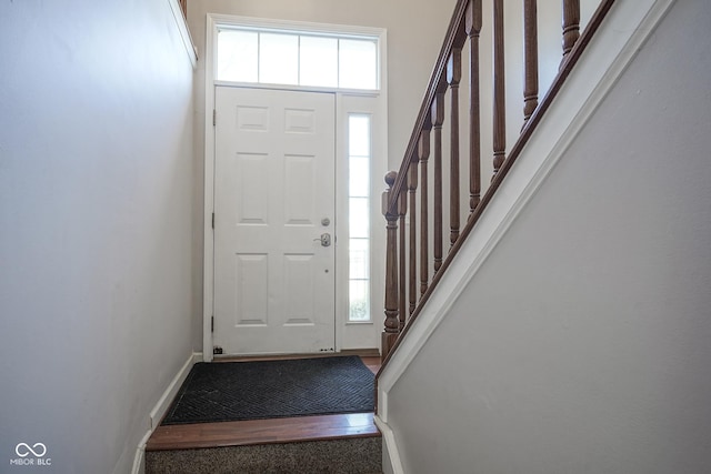 entryway with a wealth of natural light, baseboards, and stairs