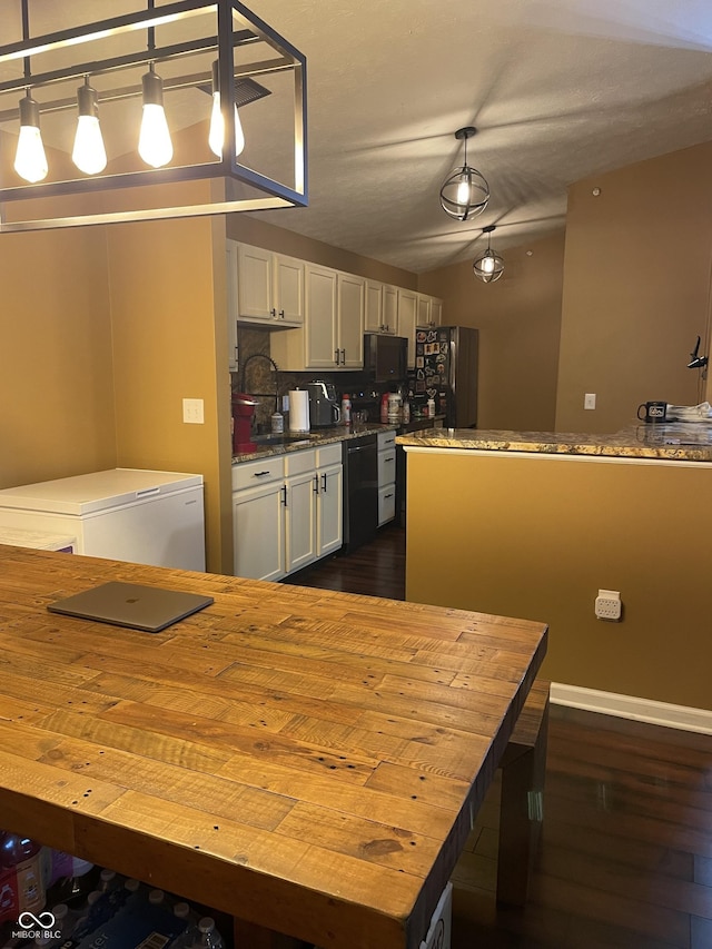 kitchen with decorative light fixtures, white cabinets, vaulted ceiling, a sink, and black appliances