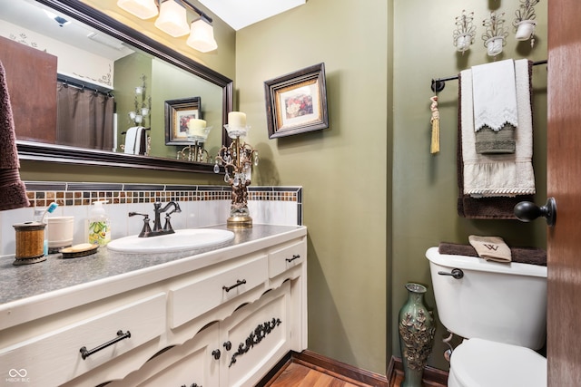 bathroom featuring vanity, backsplash, and toilet