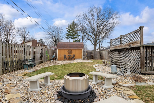 view of yard with a fenced backyard, an outdoor structure, and a storage shed