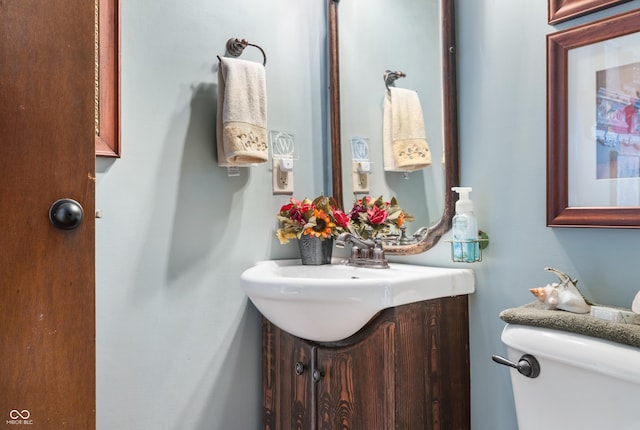 half bath featuring toilet and vanity