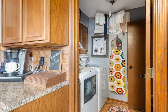 clothes washing area with washing machine and clothes dryer and cabinet space