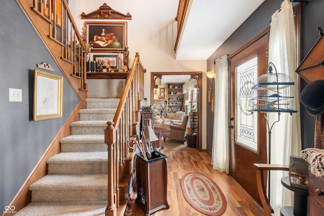 entrance foyer with stairway, baseboards, and wood finished floors