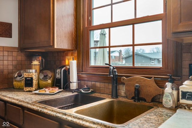 kitchen featuring light countertops, backsplash, and a sink