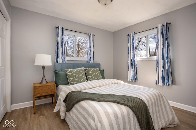 bedroom with baseboards and wood finished floors