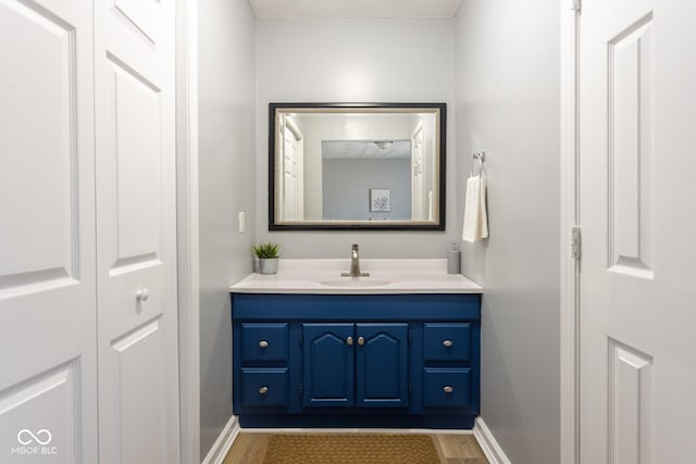 bathroom featuring baseboards, wood finished floors, and vanity