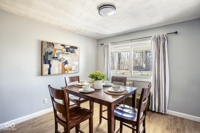 dining area with wood finished floors and baseboards