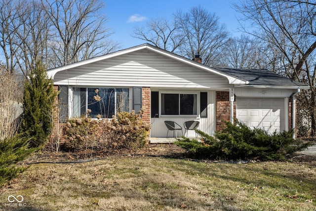 view of front of home featuring a front lawn, brick siding, a chimney, and an attached garage