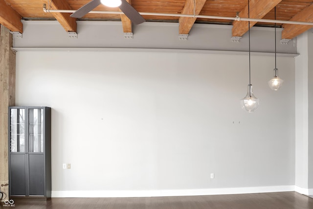 spare room with beamed ceiling, baseboards, and wood finished floors