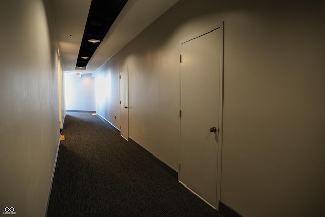 hall featuring dark colored carpet