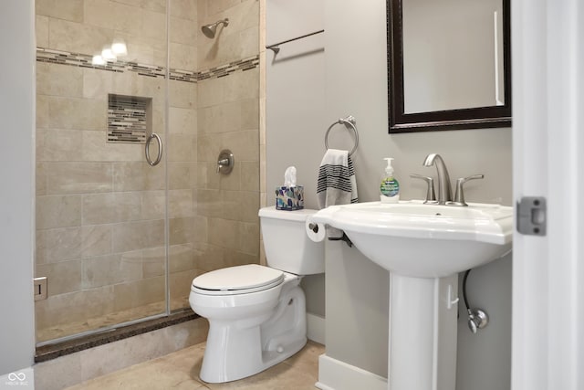 bathroom featuring toilet, a shower stall, and tile patterned floors