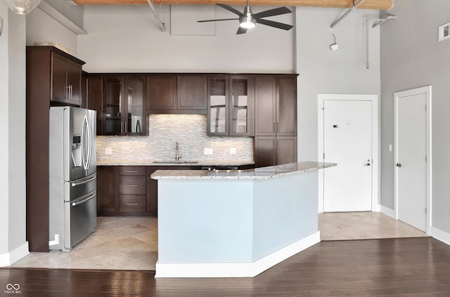 kitchen with stainless steel refrigerator with ice dispenser, visible vents, a sink, dark brown cabinetry, and ceiling fan