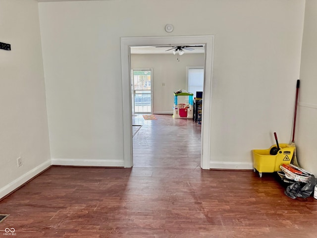 hallway featuring baseboards and wood finished floors