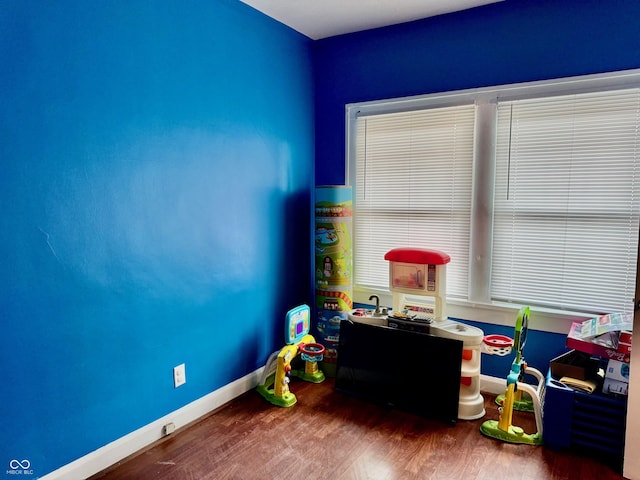 playroom with baseboards and wood finished floors