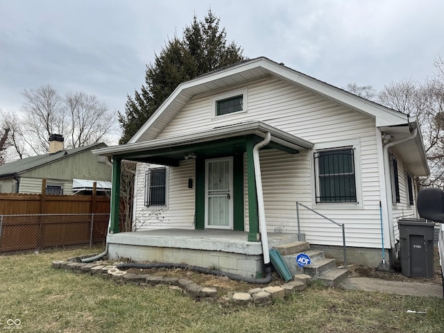 view of front of property featuring fence and a porch