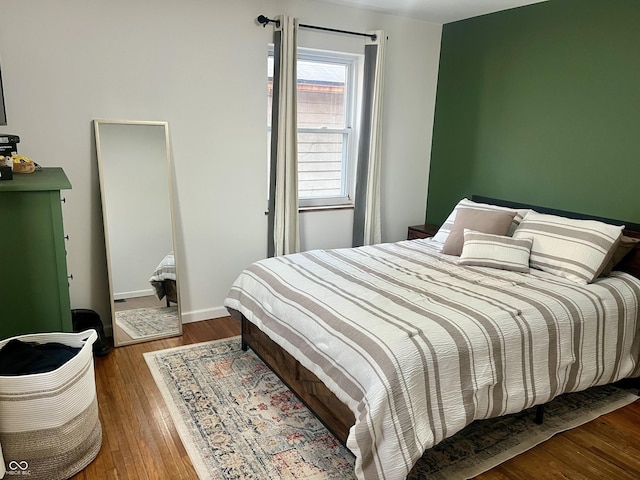 bedroom featuring baseboards and wood finished floors