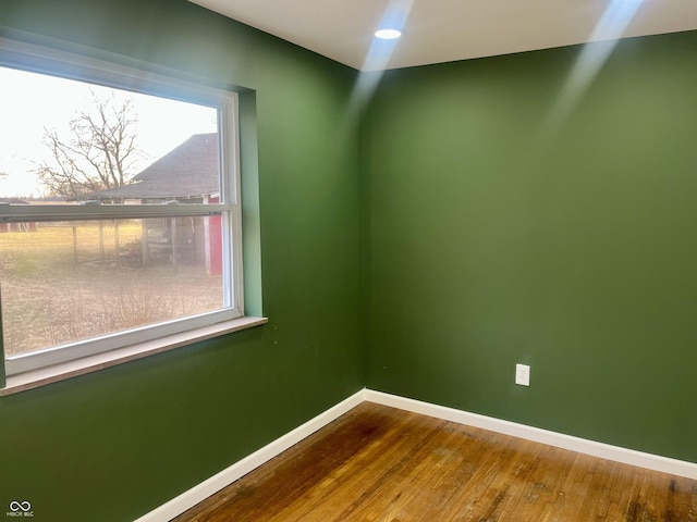 empty room with recessed lighting, wood finished floors, and baseboards